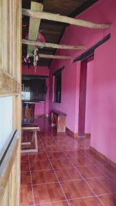 um quarto vazio com paredes cor-de-rosa e piso em azulejo em El Gran Chaparral em Siguatepeque