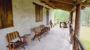 a group of wooden chairs sitting on a porch at El Gran Chaparral in Siguatepeque
