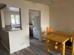 a kitchen with a wooden table and a refrigerator at One Bedroom Executive Condo Close to UNR and TMCC in Reno