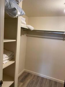 a room with a closet with shelves and a door at One Bedroom Executive Condo Close to UNR and TMCC in Reno