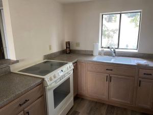 a kitchen with a white stove and a sink at One Bedroom Executive Condo Close to UNR and TMCC in Reno