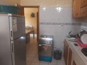 a kitchen with a refrigerator and a stove in it at Ya-Penda in Ndangane