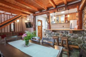 a dining room and kitchen with a stone wall at Cabañas Tierra Mistica in Ushuaia