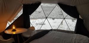 a window in a tent with a bed and a table at Boulder Mountain Resort in Revelstoke