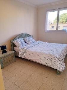 a bedroom with a bed and a window at Appartement F3 avec balcon in Perpignan