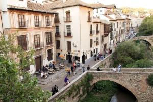 een oude brug over een straat in een stad bij Bonito duplex bajo Alhambra in Granada