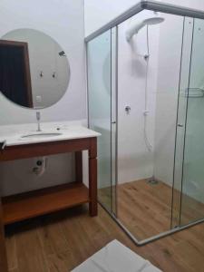 y baño con ducha, lavabo y espejo. en Casas de alto padrão em Condominio Privado, en Chapada dos Guimarães