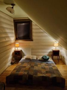 a bedroom with a bed with two lamps on two tables at Zrubík pod Znievom (Log Cabin Zniev) 