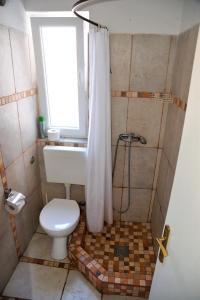 a bathroom with a toilet and a window and a shower at Apartment Art Adriatic in Punat