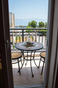 a table and chairs on a balcony with a candle at Rooms Nancy in Agios Andreas