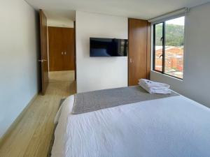 une chambre avec un grand lit et une grande fenêtre dans l'établissement Tranquilidad descanso y cultura Tekto, à Bogotá