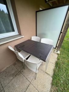 a table and chairs sitting next to a window at L’entrelacs in Équemauville