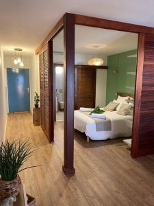 una camera con un letto e un grande specchio di KARUK'IDîLE-Appartement Vue Mer - Plage à 200m a Gourbeyre