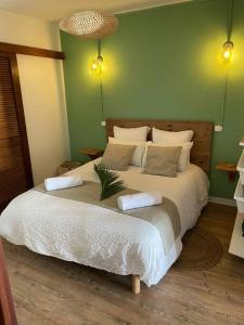 um quarto com uma cama grande e 2 almofadas em KARUK'IDîLE-Appartement Vue Mer - Plage à 200m em Gourbeyre
