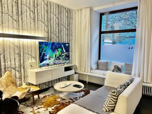 a living room with a couch and a tv at Cocoma-Design-Apartment Deluxe - very central in Munich