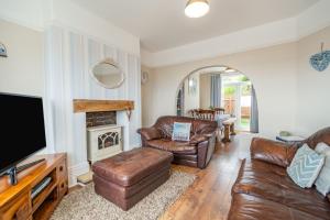 a living room with leather furniture and a flat screen tv at Sea View House in Hornsea