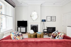 a living room with a red couch and a fireplace at Sonder King Street in London