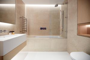 a bathroom with a shower and a sink and a tub at Sonder King Street in London