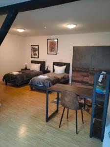 Zimmer mit 2 Betten, einem Tisch und einem Schreibtisch in der Unterkunft Urban Living unter den Dächern der Göttinger Altstadt in Göttingen