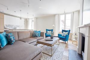 een woonkamer met een bank en blauwe stoelen bij Sonder King Street in Londen