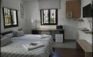 1 dormitorio con 1 cama, escritorio y ventanas en Hotel Rural Aznaitín, en Albanchez de Úbeda