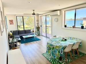a living room with a table and a couch at Cosy unit with park & water view in Ballina
