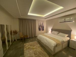 a bedroom with a large bed and a room with a table at شقه (غرفه+صاله)مطله على المركز المالي بدخول ذاتي in Riyadh