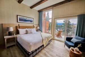 a bedroom with a bed and a window and a chair at Pyramid Lake Lodge in Jasper