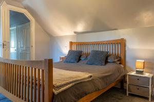 una camera con letto in legno e cuscini blu di The Crown Inn a Sarre