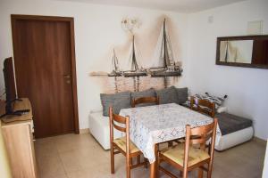 uma sala de jantar com mesa e cadeiras e um barco na parede em Apartmani Nede em Trogir