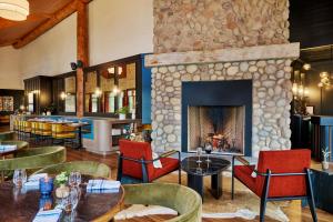 un ristorante con camino, tavoli e sedie di Pyramid Lake Lodge a Jasper