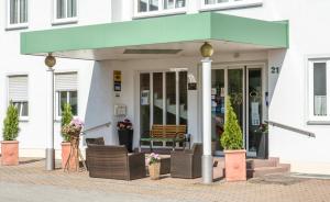 a building with a green awning on the sidewalk at Hotel St. Martin in Marktoberdorf