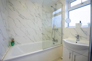 a white bathroom with a sink and a shower at Entire Home Contractors, Relocators Monthly or Weekly Stay in Norwood