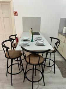 una mesa con sillas y platos y un jarrón con flores en City Appartementen New Nickerie - 4p, en Nieuw Nickerie