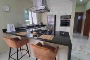 a kitchen with a counter with two bar stools at So Lovely Apartment near Bonita Beach in Las Terrenas
