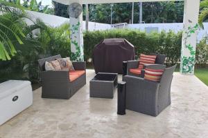 a patio with three chairs and a table at So Lovely Apartment near Bonita Beach in Las Terrenas