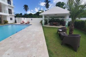 un patio trasero con cenador y piscina en So Lovely Apartment near Bonita Beach, en Las Terrenas