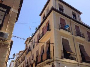 a tall building with balconies on a street at Pension La Milagrosa in Granada