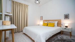 a bedroom with a large white bed with yellow pillows at La casa Nikol Meteora in Kalabaka