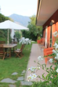 eine Terrasse mit einem Tisch, Stühlen und einem Sonnenschirm in der Unterkunft Agriturismo da Luì in Bordighera