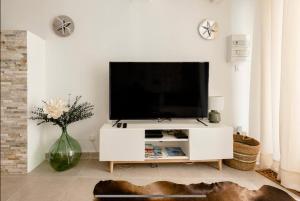 ein Wohnzimmer mit einem TV auf einem weißen Entertainment-Center in der Unterkunft CASA RELAX Appart cocooning dans village provençal in Montfort-sur-Argens