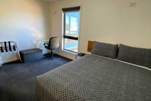 Un dormitorio con una cama grande y una ventana en Wild Rivers Escape en Strahan