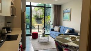 a living room with a blue couch and a table at Cozy apartment with terrace, SJ Cosmopolitan Tower #402 in San José