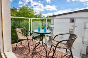 a balcony with a table and two chairs on it at Apartament "Szczęśliwa 13" in Dziwnówek