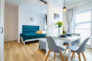a bedroom with a bed and a table and chairs at Apartament "Szczęśliwa 13" in Dziwnówek