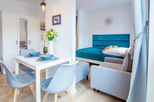 a room with a table and chairs and a bed at Apartament "Szczęśliwa 13" in Dziwnówek