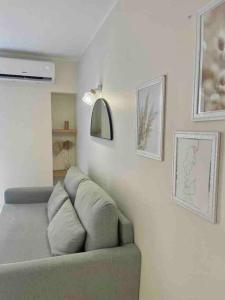 uma sala de estar com um sofá e quadros na parede em Le BASHKIR em Nice