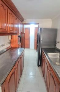 cocina con armarios de madera y nevera de acero inoxidable en Acogedor y Residencial piso 3 en Cartagena de Indias