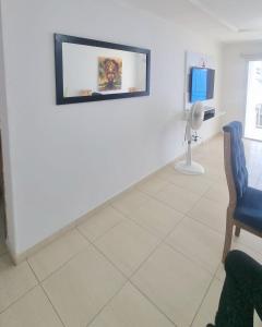 a room with a white wall and a chair and a fan at Acogedor y Residencial piso 3 in Cartagena de Indias