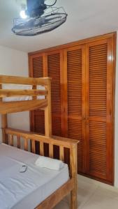 1 dormitorio con litera, paredes y ventanas de madera en Acogedor y Residencial piso 3, en Cartagena de Indias